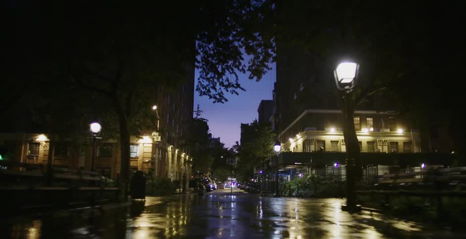 A wet and empty city street at night