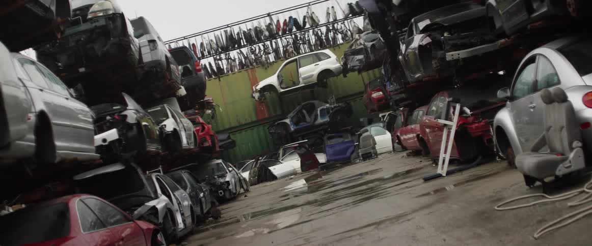 Stripped cars are stacked in an auto parts junkyard