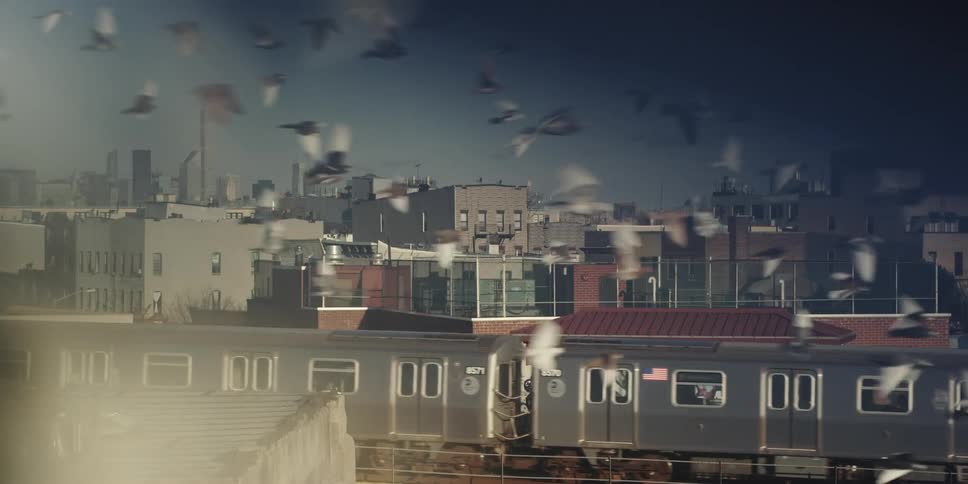 A train drives by a graffitied building