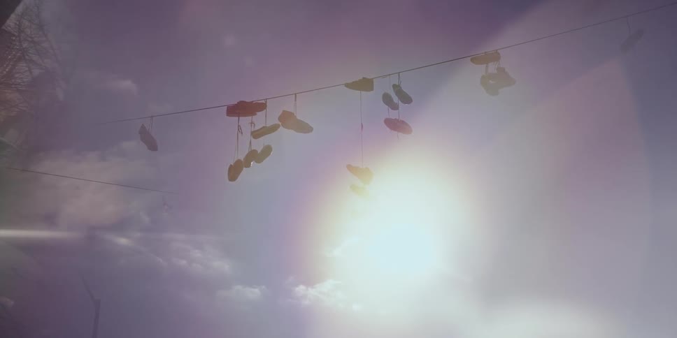 Sneakers hang from a wire across an intersection