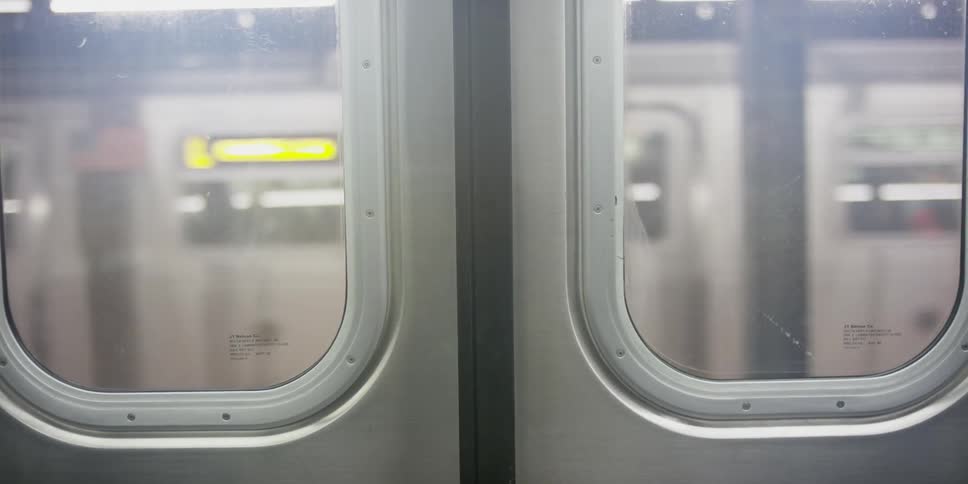 Train doors close in a station as one train leaves