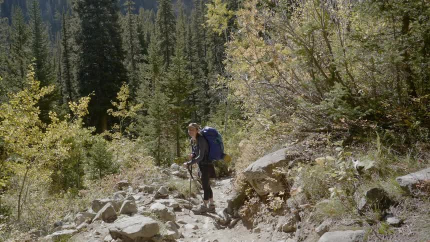 A woman laughs as she hikes on the trail