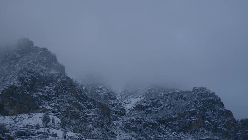 Clouds over snowy mountain peak