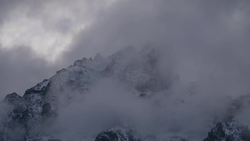 Clouds over a snow covered mountain