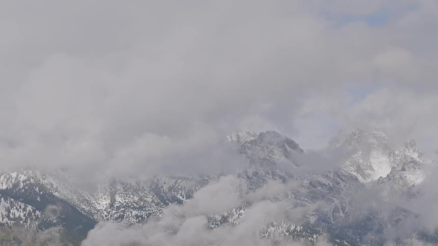 Clouds with mountains covered with snow and the sky in the background