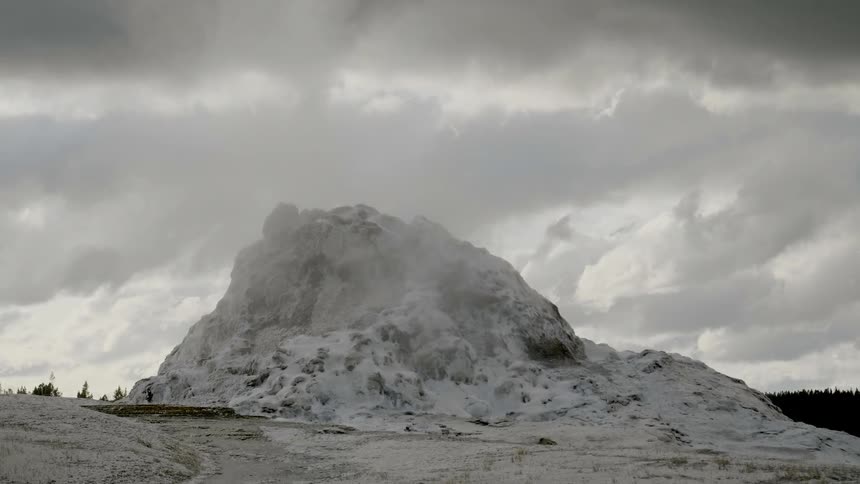 Heavy clouds float over a snow covered mountain