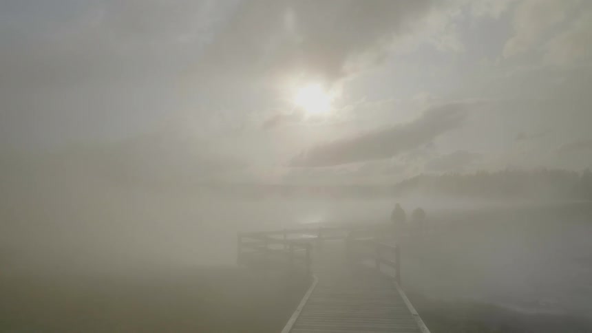 Thick fog covers a pedestrian bridge