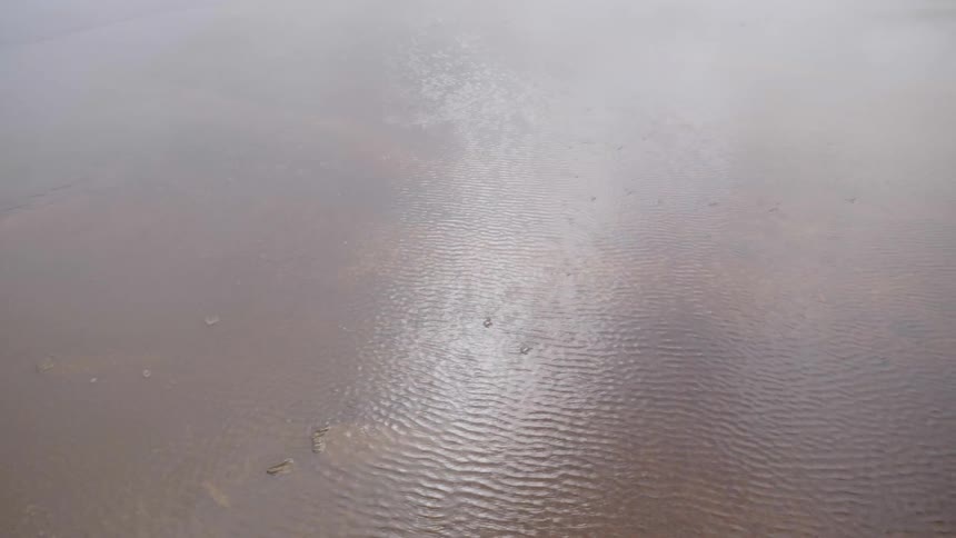 A shallow lake is shown with water slowly flowing downward at day