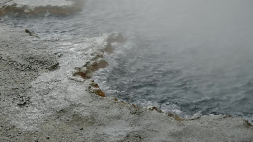 Water bubbling and steam rising in a puddle