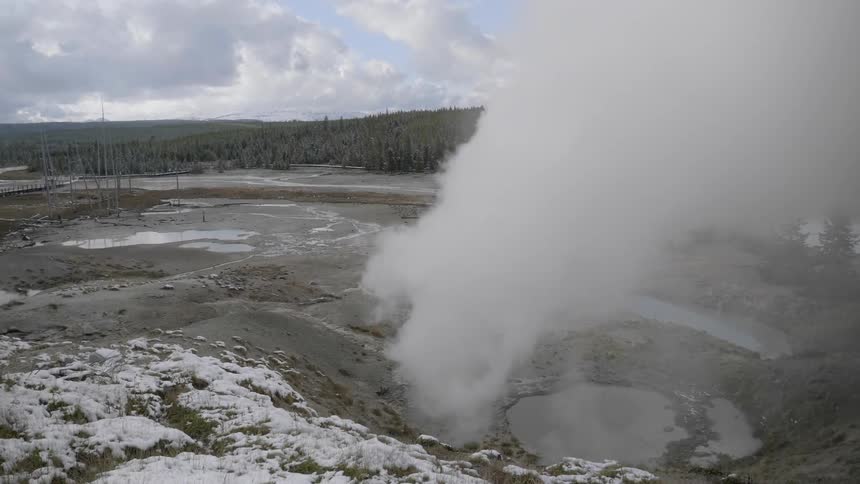 A large cloud of white steam pours out from the ground