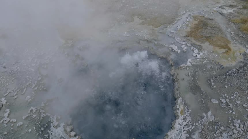 A small geyser is bubbling hot steam