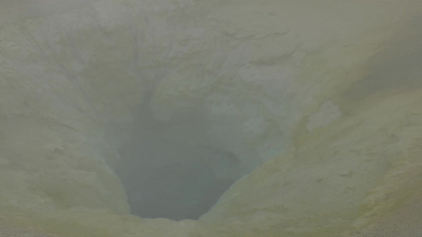 A hole in the ground covered in steam
