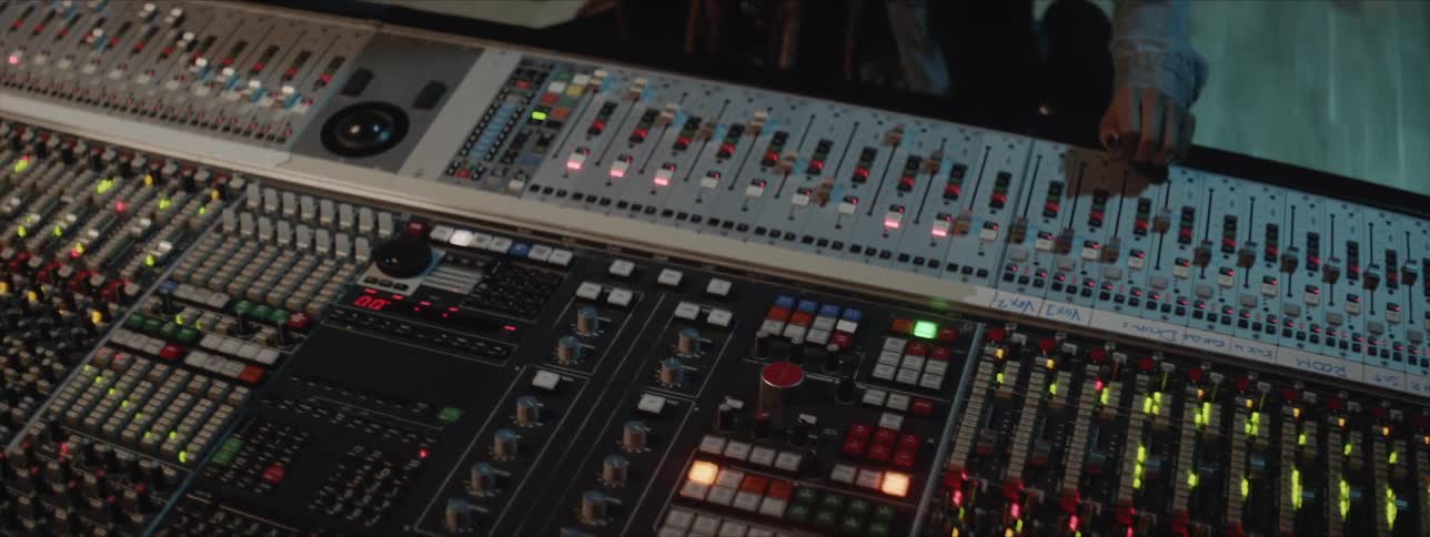 A black man works on a large soundboard