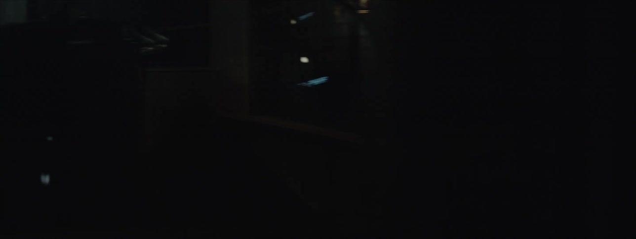 An dreadlocked studio engineer is recording a drummer who is playing while wearing a hat