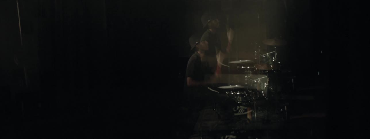 A man plays the drums in a studio