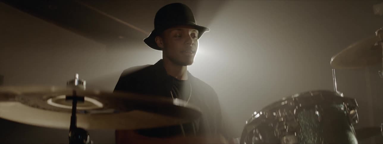 A man is playing drums indoors