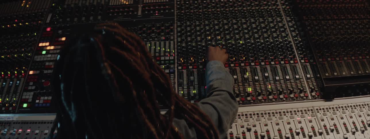 Audio engineer mixing music on console in studio