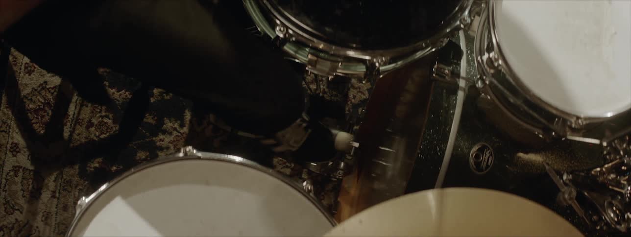 A young man is playing drums