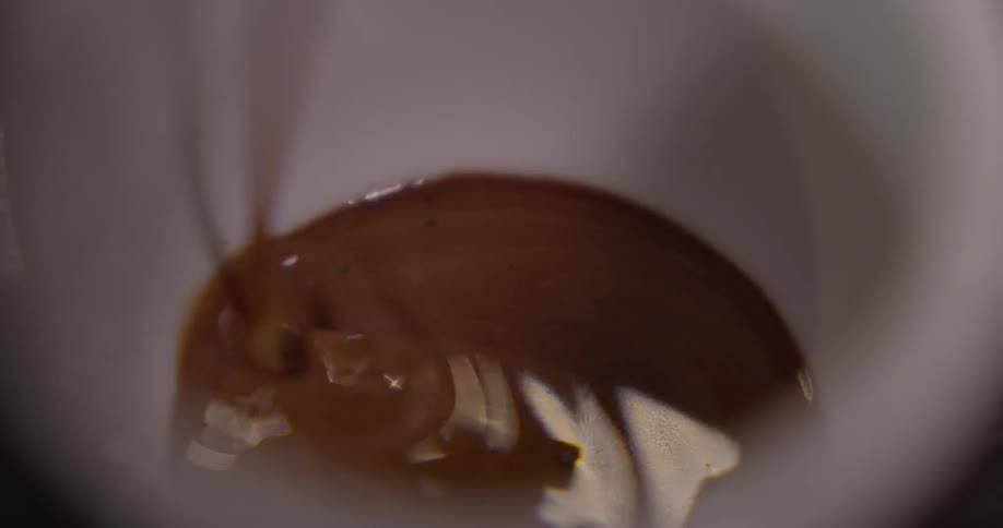 Coffee slowly brewing in a white mug