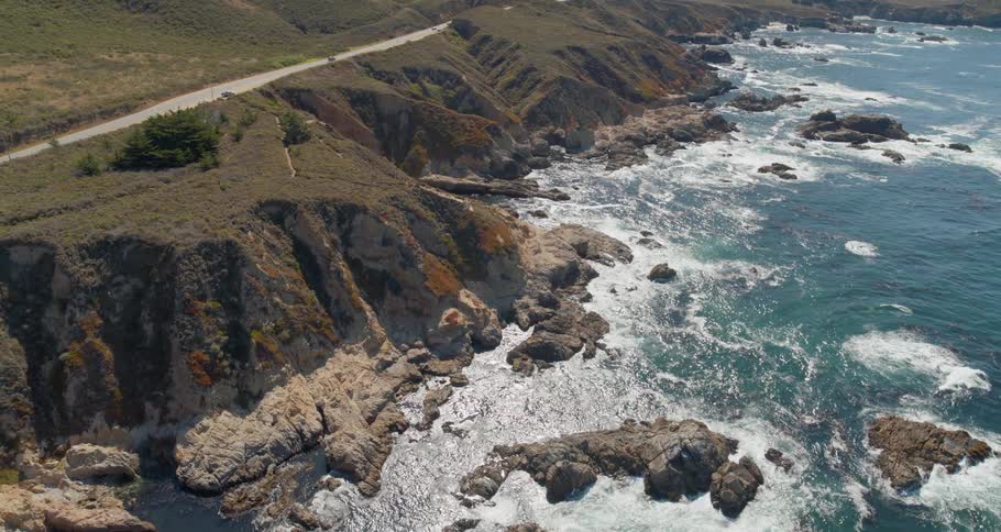The cars drive past the road on the hill by the shore