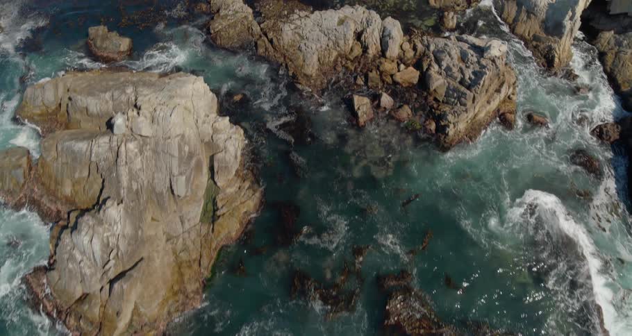 Aerial view of ocean waves crashing on coastal rocks
