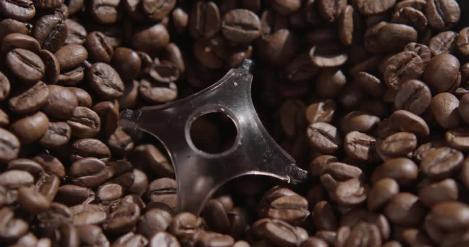 Coffee beans drain down through a hole in a machine