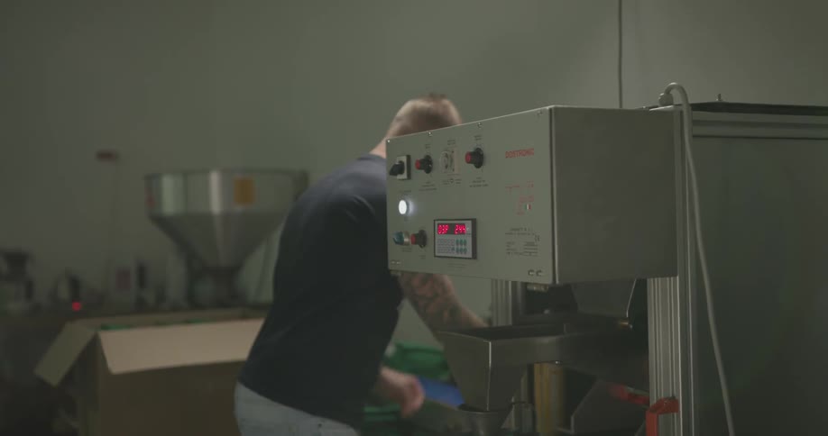 Man working on workshop using a packaging machine