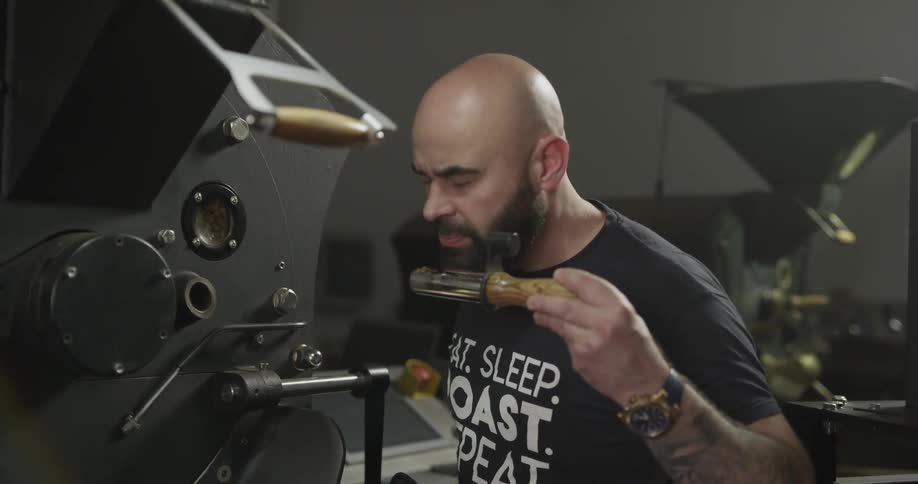A bald man checks something on a machine