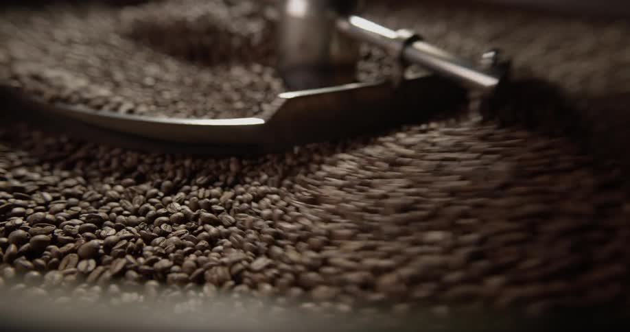 Rotors stir coffee beans in an industrial sized grinder