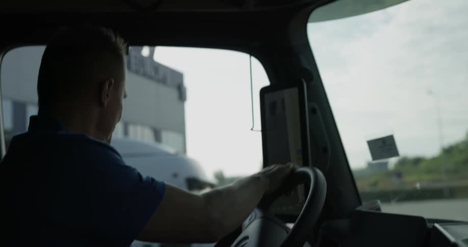 A man turns the steering wheel of a large truck