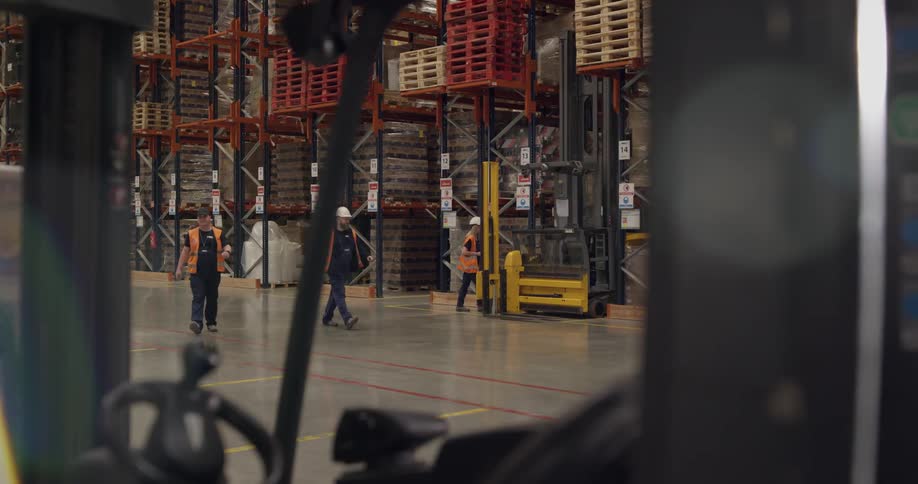 Several workers walk through a warehouse