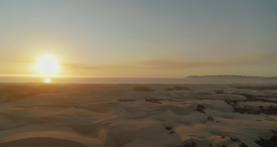 The sun rises over an icy and snow covered landscape