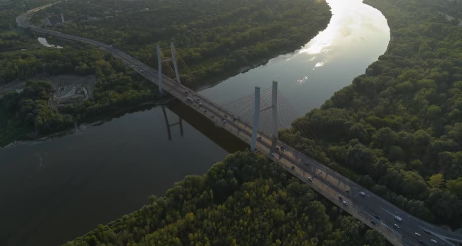 Traffic flows on a suspension bridge that spans a river
