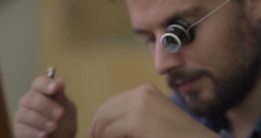 Man looking through a mini magnifying glass