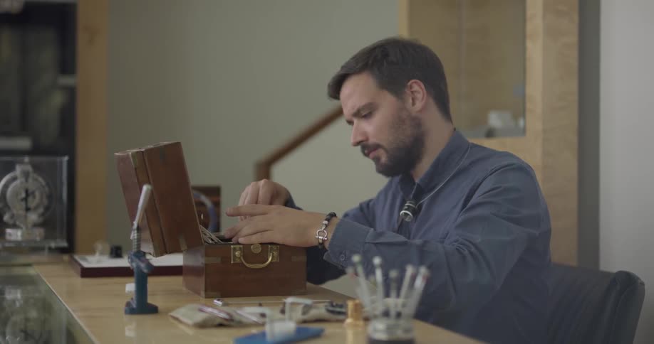 A man examining a device in a wooden box