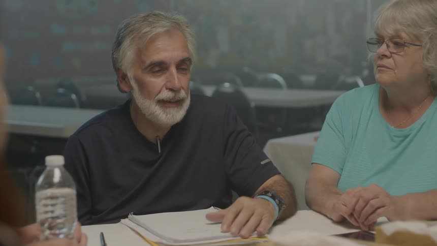 A man is talking with others at the table