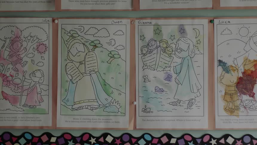 Pages are tacked on the wall and partially colored