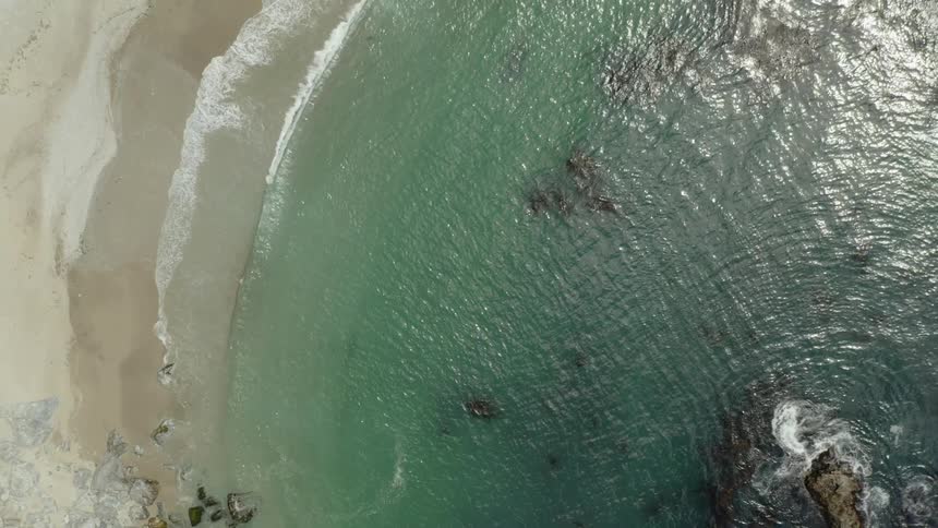 Clear ocean waves breaking over the sandy beach