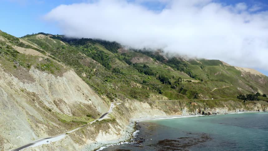 Clouds float over a mountainous coastline