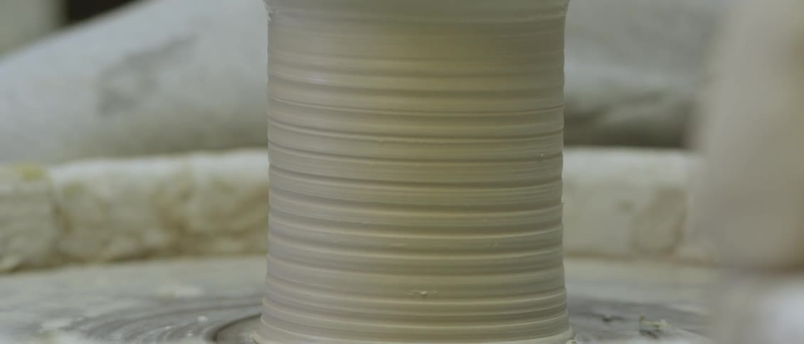 A person is making an object with clay