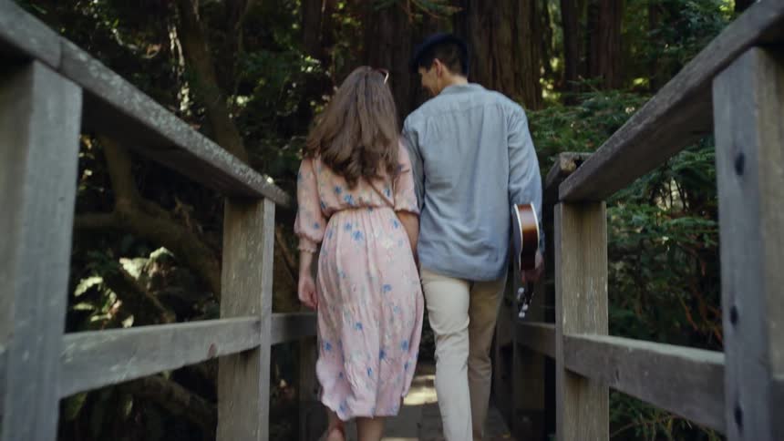 Couple walking across a wooden bridge