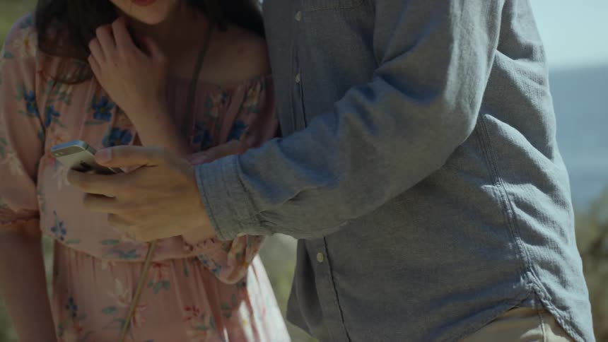 A man and woman look at something on a smart phone