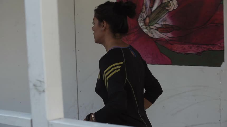 A woman is running near a white wall