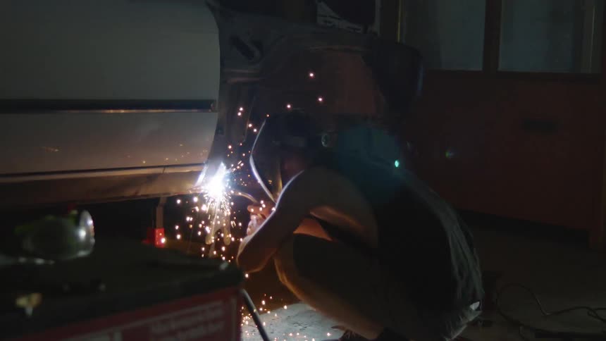 A welder works on a car