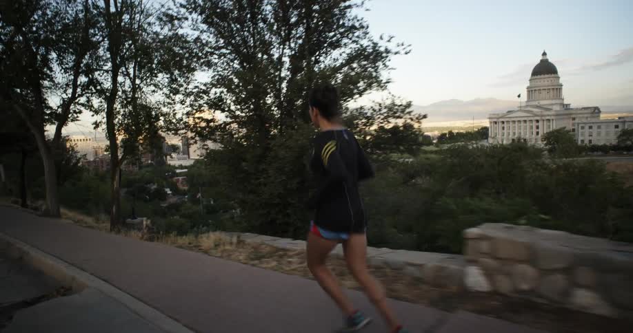 A woman runs down a sidewalk