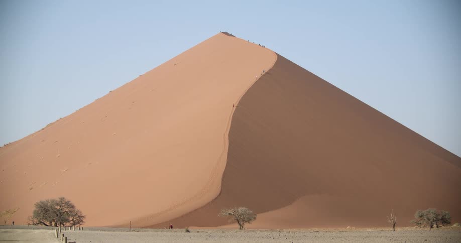 People hike up a huge sand dune