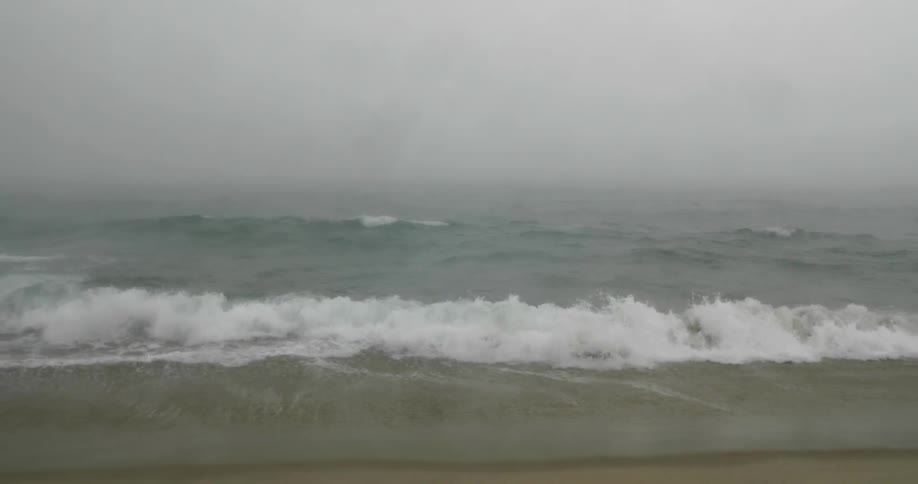 Several waves roll into a beach