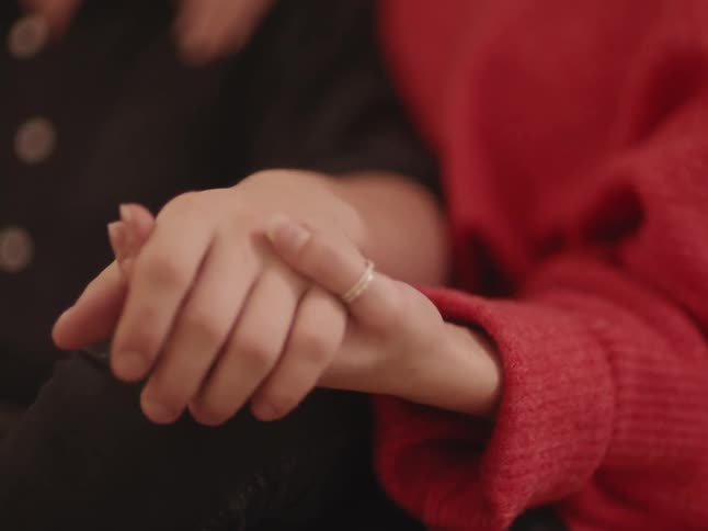 Two white people hold hands
