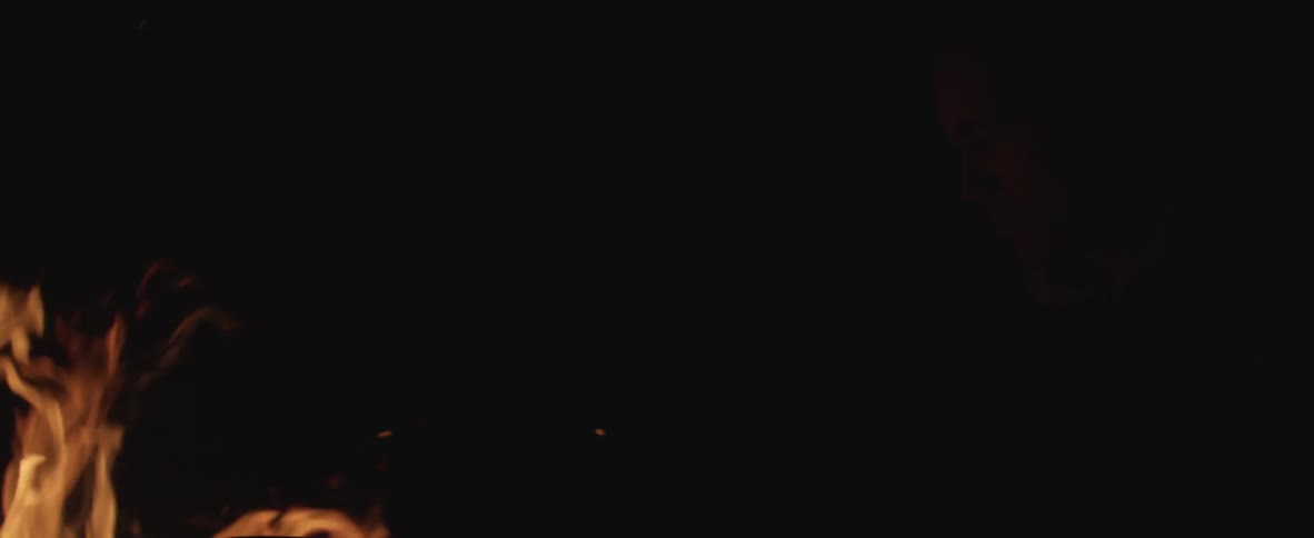 Flickering flames and rising embers at night