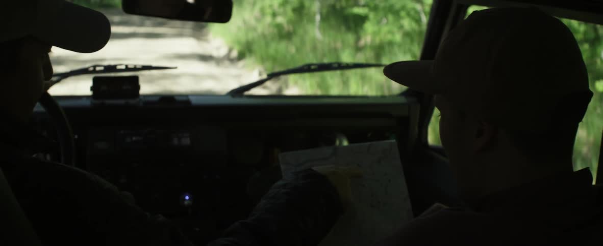 Two people looking at a map while driving